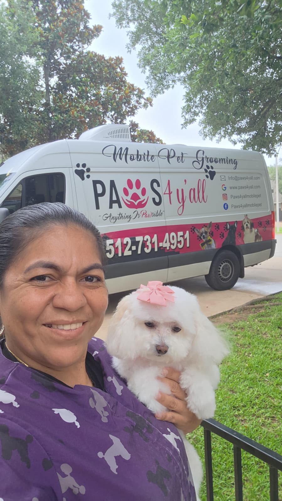 Ana Belén smiling with a happy groomed dog beside the mobile grooming van